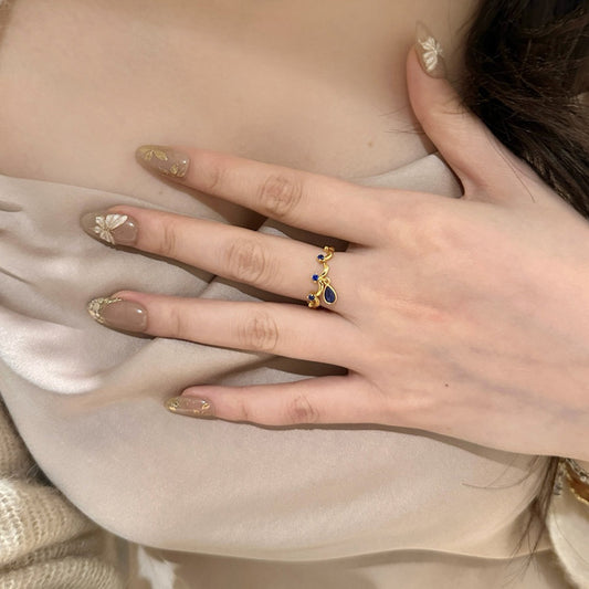 A blue teardrop ring with ancient glass craftsmanship and lace