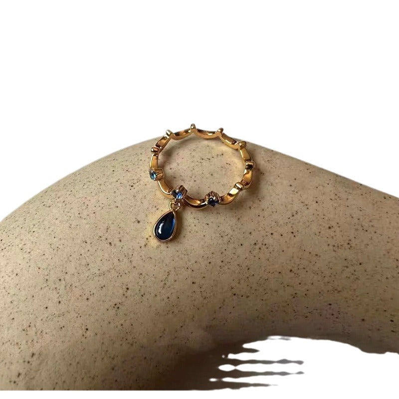 A blue teardrop ring with ancient glass craftsmanship and lace