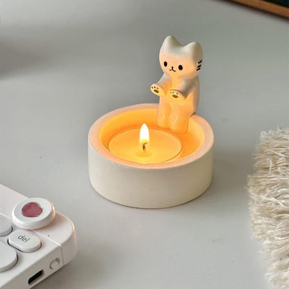 A cat is warming itself by the fire candlestick