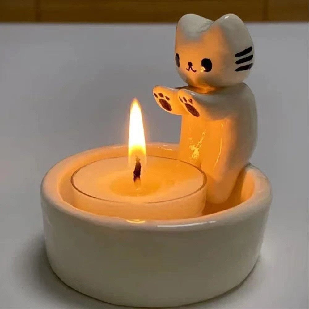 A cat is warming itself by the fire candlestick