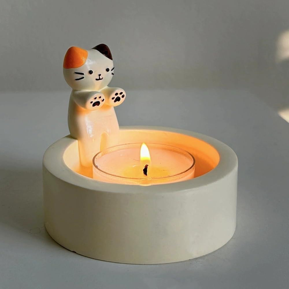 A cat is warming itself by the fire candlestick