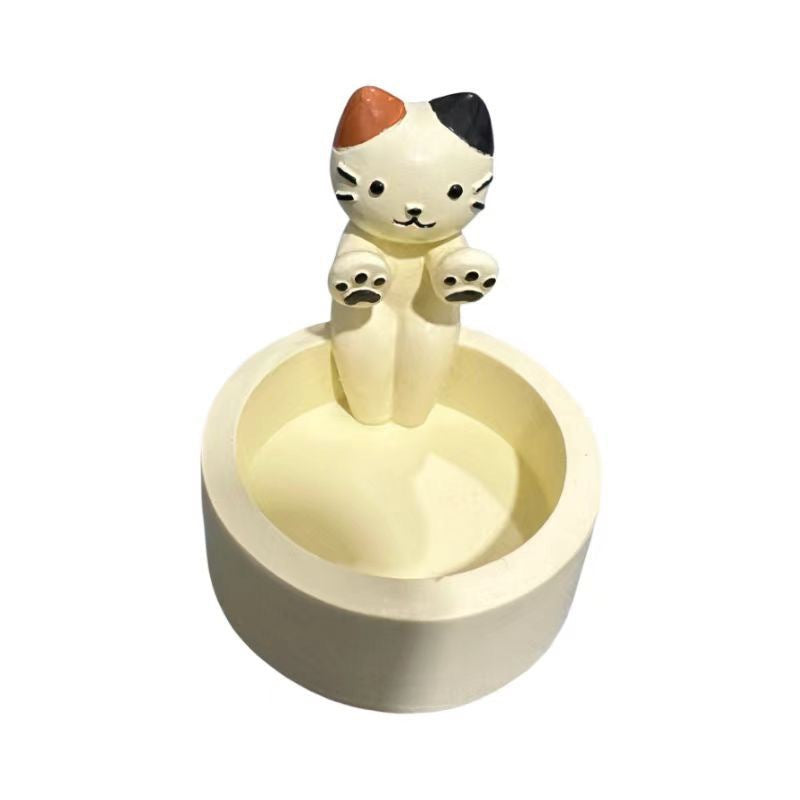 A cat is warming itself by the fire candlestick