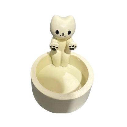 A cat is warming itself by the fire candlestick