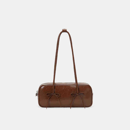 A red female baguette bag with a bow