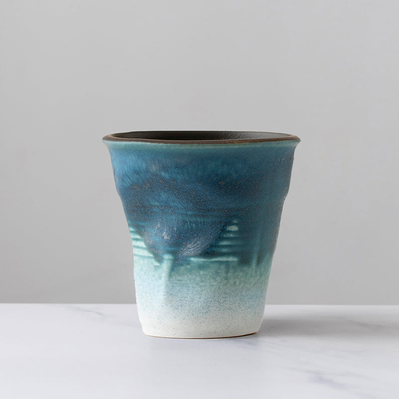 A rough pottery hand-molded pleated cup