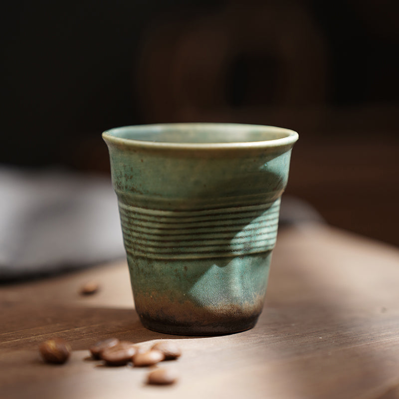 A rough pottery hand-molded pleated cup