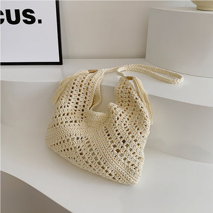 A single-shoulder hand-held women's bag made of straw with a drawstring inner pocket