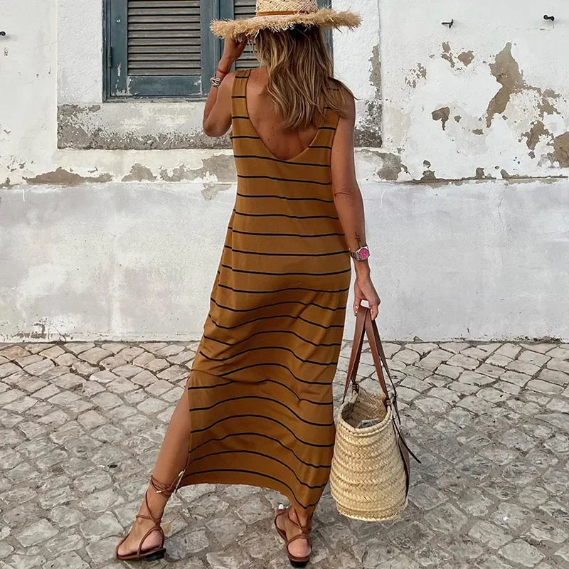 A sleeveless, high-waisted, form-fitting, low-necked long dress