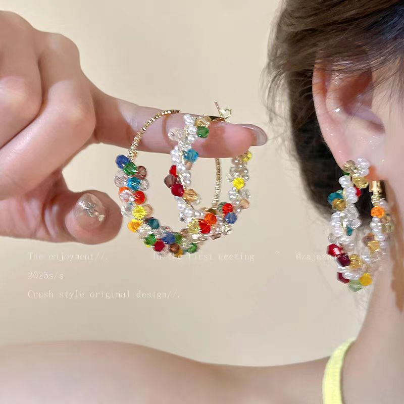 A woman with dazzling pearls wrapped around her ear loops