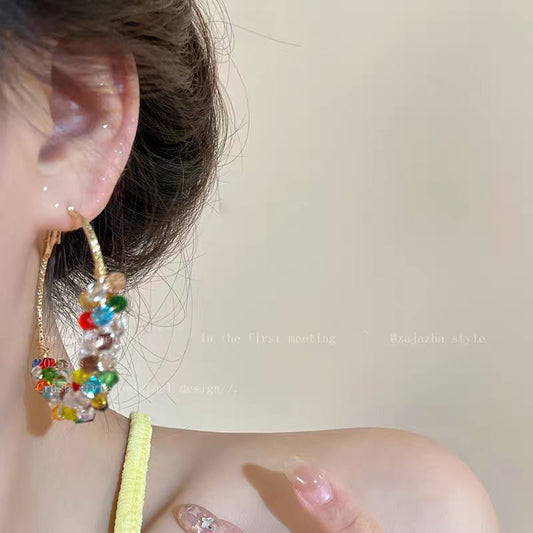 A woman with dazzling pearls wrapped around her ear loops