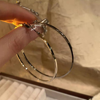 A woman with plain hoop earrings