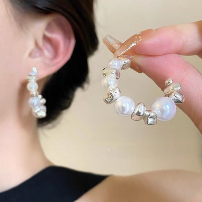 A woman with plain hoop earrings