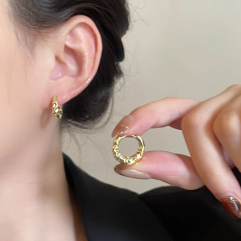 A woman with plain hoop earrings
