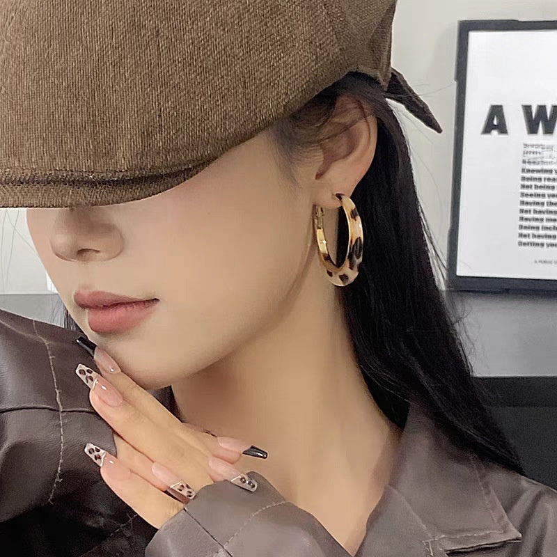A woman with plain hoop earrings