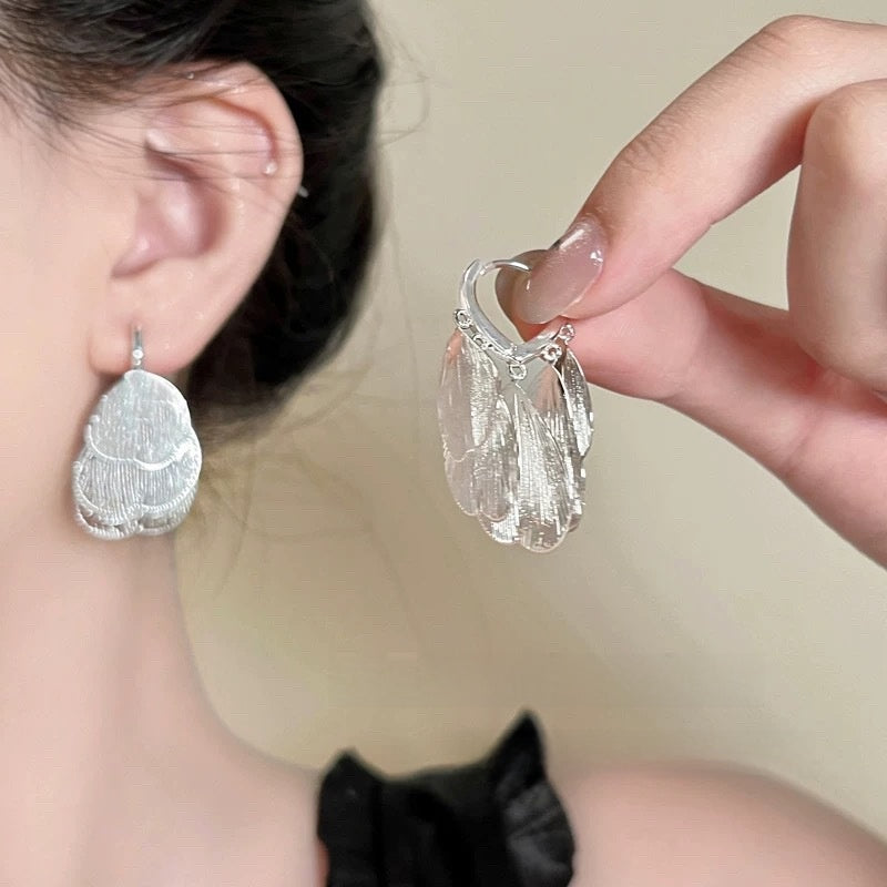 A woman with plain hoop earrings