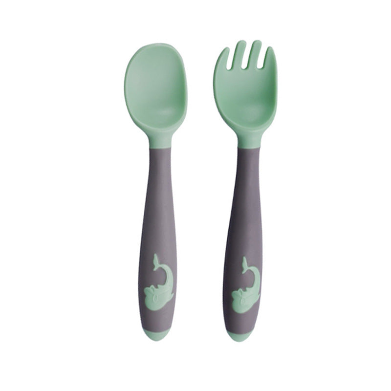 Baby learning to eat spoon and fork