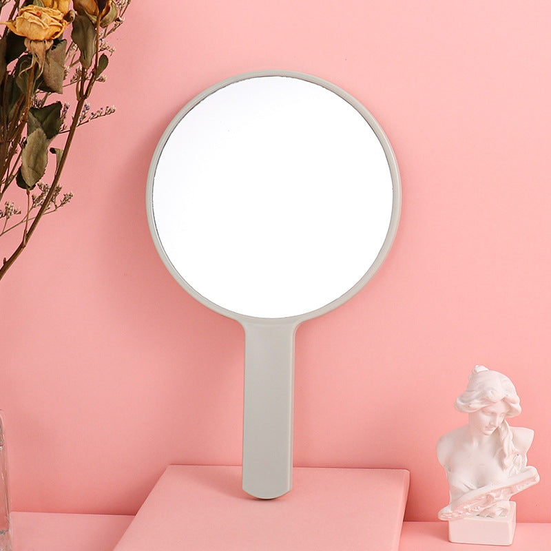 Portable plastic round-handled makeup mirror