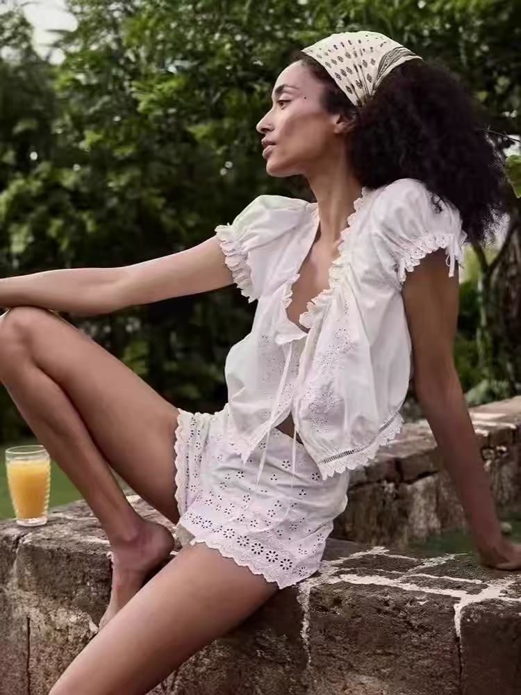 Puff-sleeve blouse with large round neckline, ruffled trim, and tie details