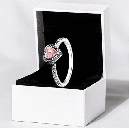White copper ring with a red heart design
