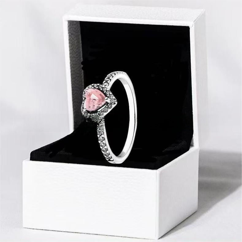 White copper ring with a red heart design