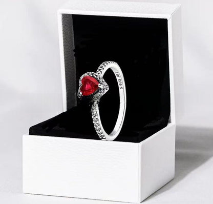 White copper ring with a red heart design